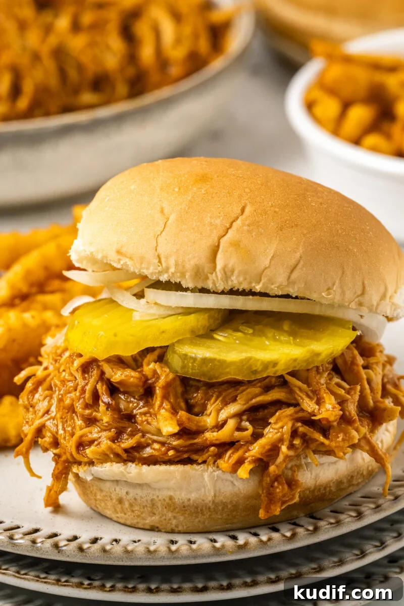 A spicy chicken sandwich on a plate with fries.