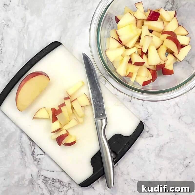 Overhead view of process shot 2 - Cut the apple into small bite-sized pieces and place in a bowl.