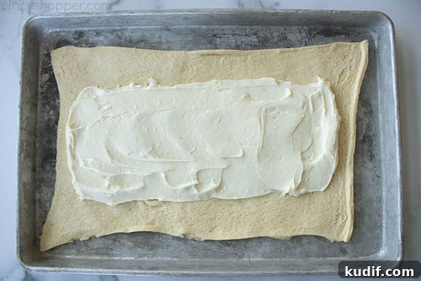 Raspberry Crescent Danish: Flaky Pastry Recipe for Brunch 11 layer of cream cheese spread onto pastry dough on a sheet pan