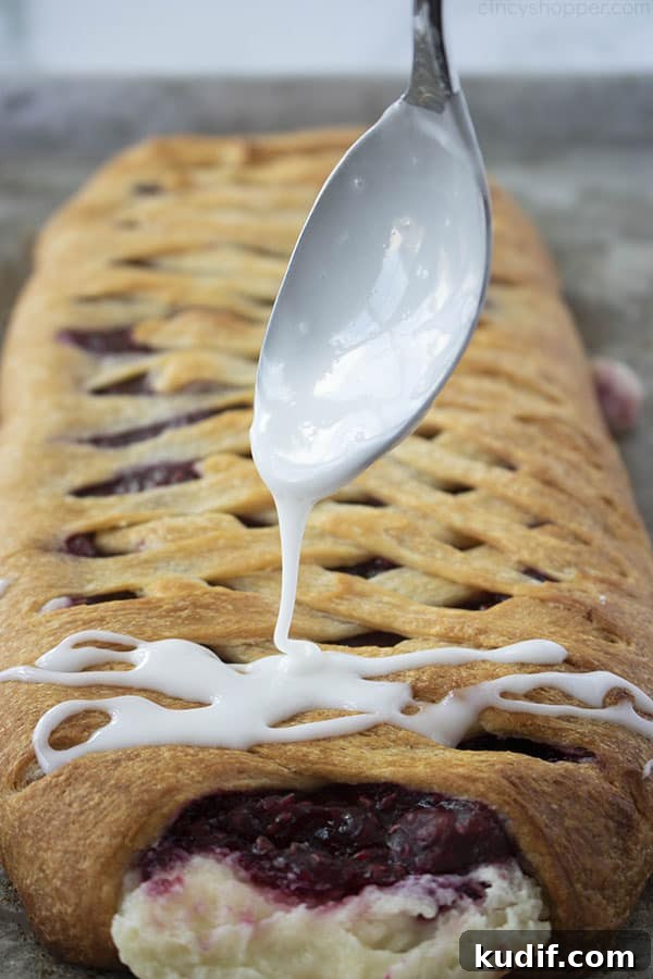 Raspberry Crescent Danish: Flaky Pastry Recipe for Brunch 15 spooning sweet icing over braided pastry dessert