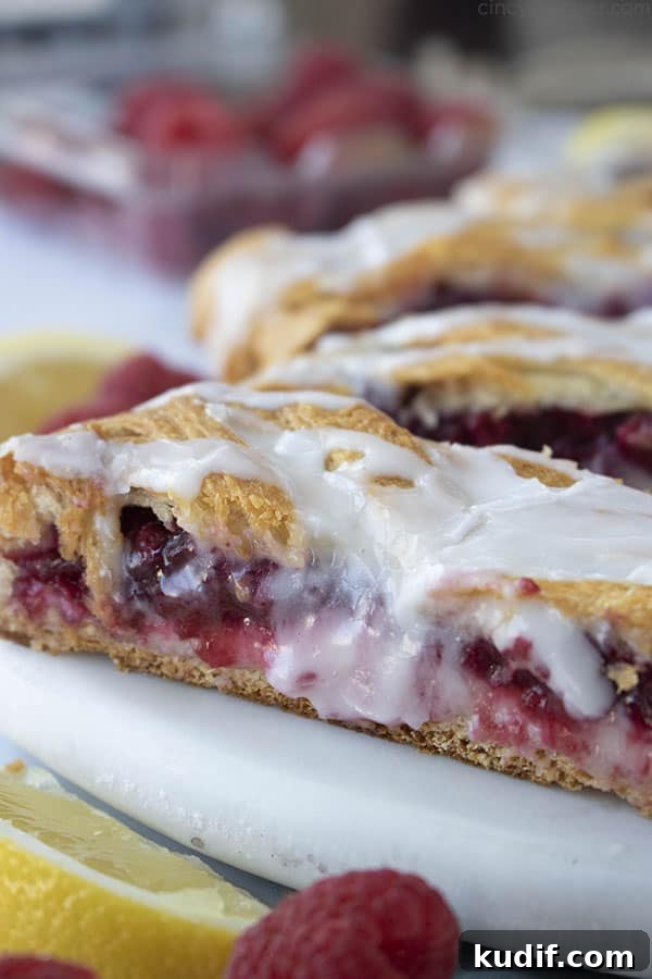 Raspberry Crescent Danish: Flaky Pastry Recipe for Brunch 3 close up slice of crescent roll raspberry pastry with icing