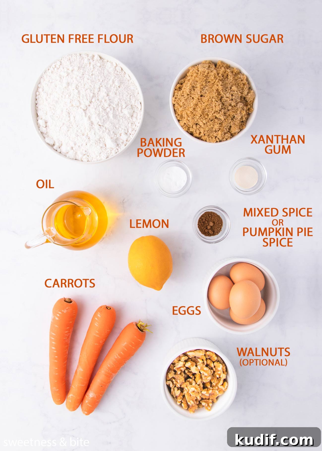 The gluten free carrot cake cupcake ingredients on a grey background with orange labels.