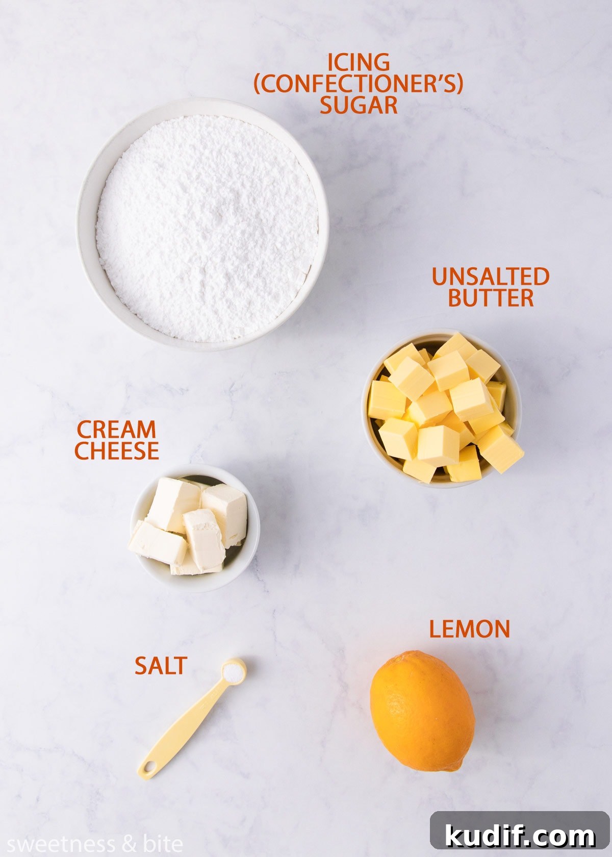 The cream cheese frosting ingredients on a grey background with orange labels.