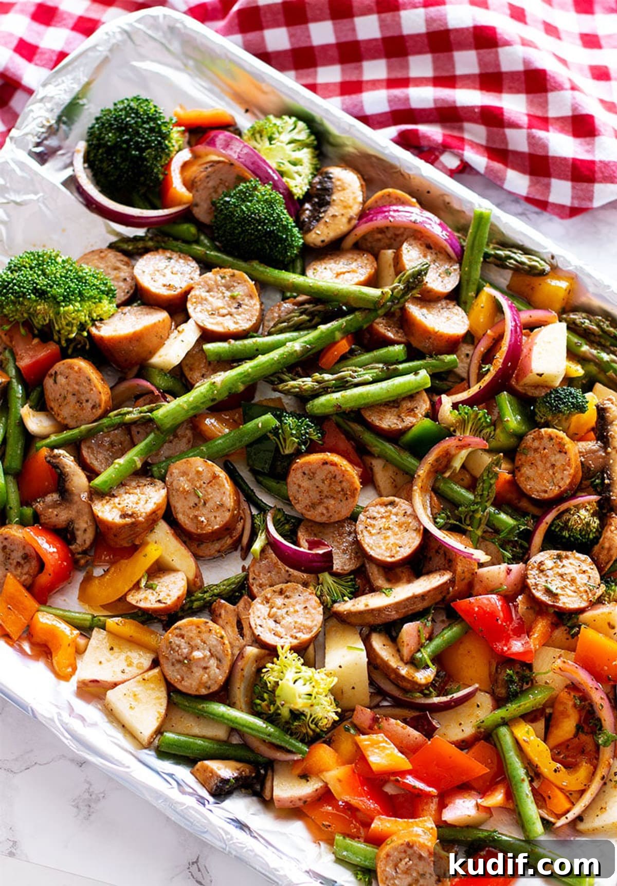 Sheet Pan Sausage with Roasted Vegetables Recipe 9 One Pan Smoked Sausage and Vegetables containing broccoli, asparagus, peppers, mushrooms and onion.