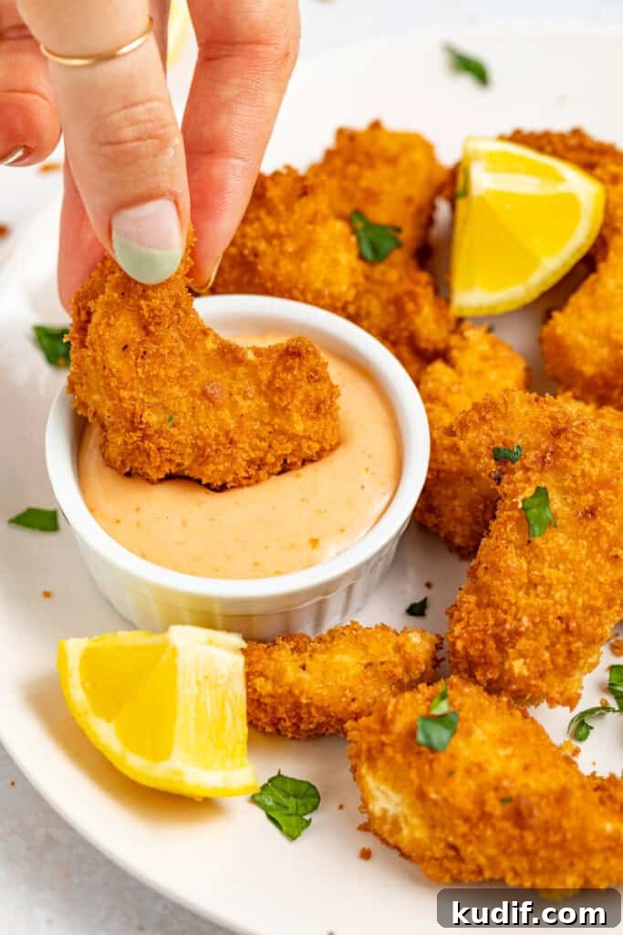Crispy Vegan Shrimp with Spicy Sriracha Mayo Dip 2 Vegan shrimp being dipping in sriracha mayo.