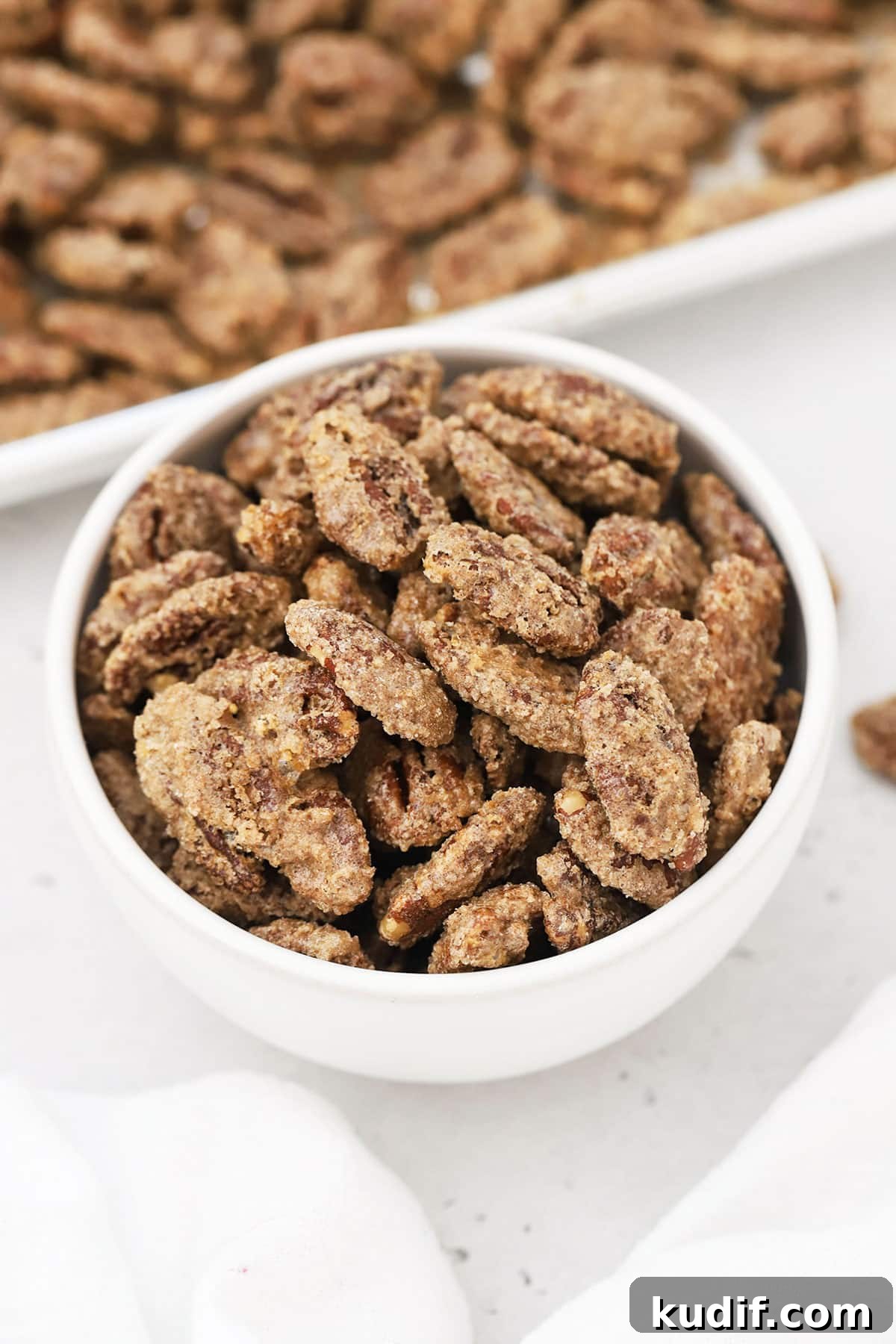 a white bowl of cinnamon sugar pecans