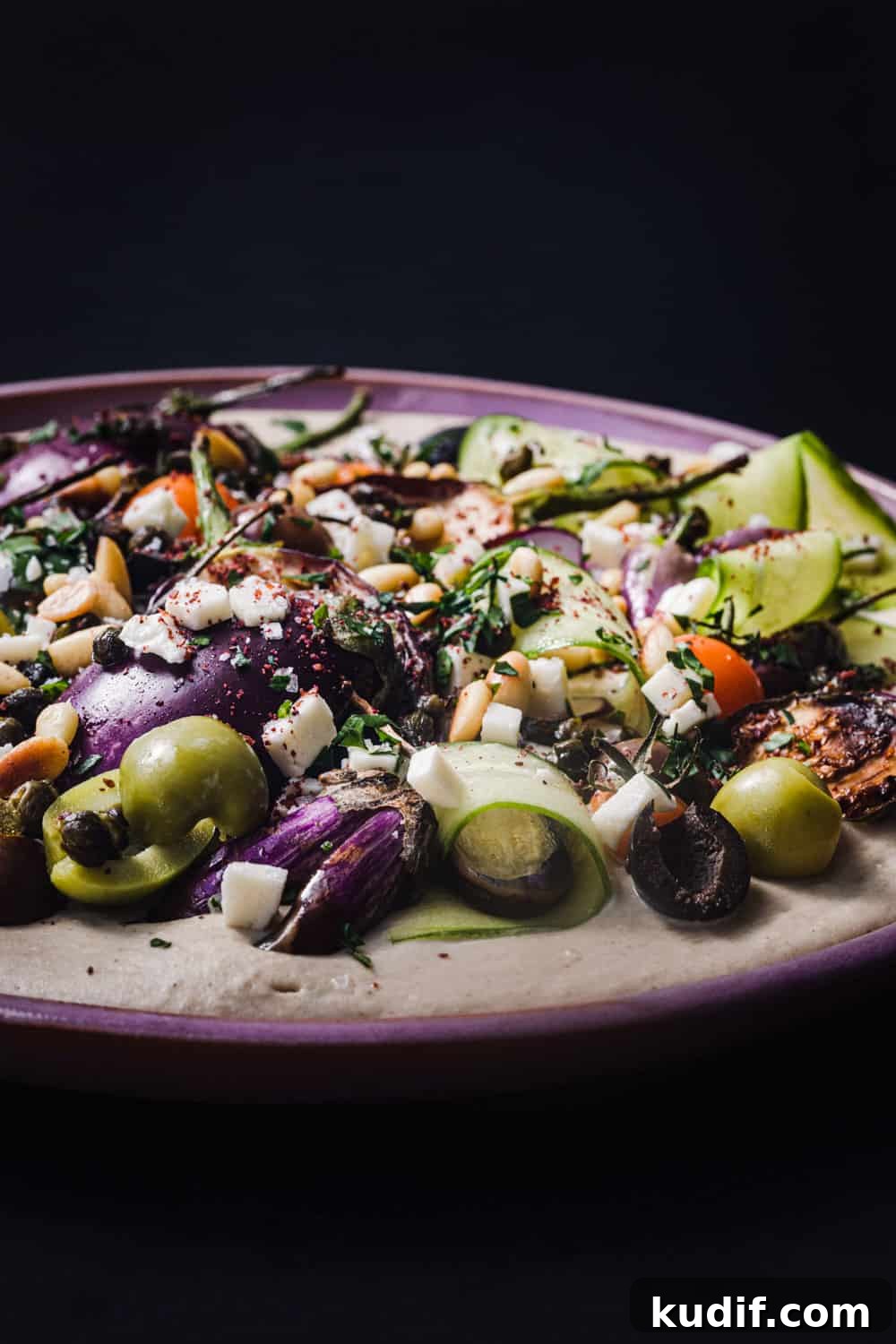 Loaded Hummus: Mediterranean 7-Layer Dip with Veggies & Feta 4 Side angle and close up loaded hummus topped with colorful vegetables, herbs and spices.