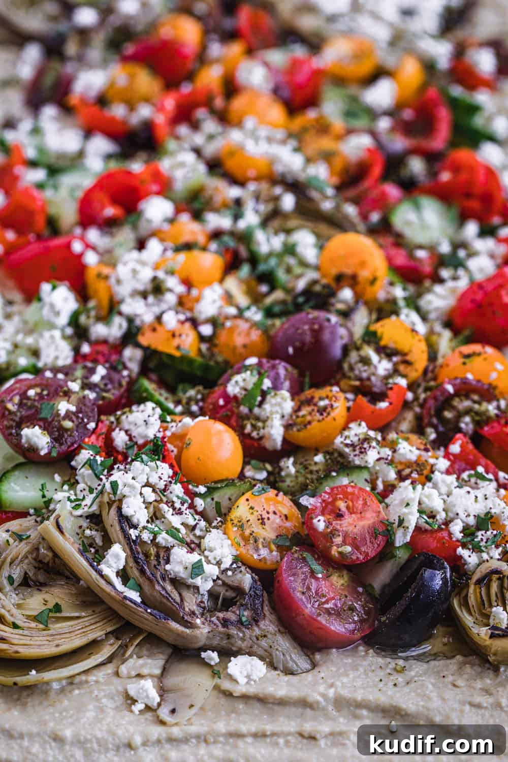 Loaded Hummus: Mediterranean 7-Layer Dip with Veggies & Feta 7 loaded hummus with very colorful toppings like cucumbers, feta, olives and morer