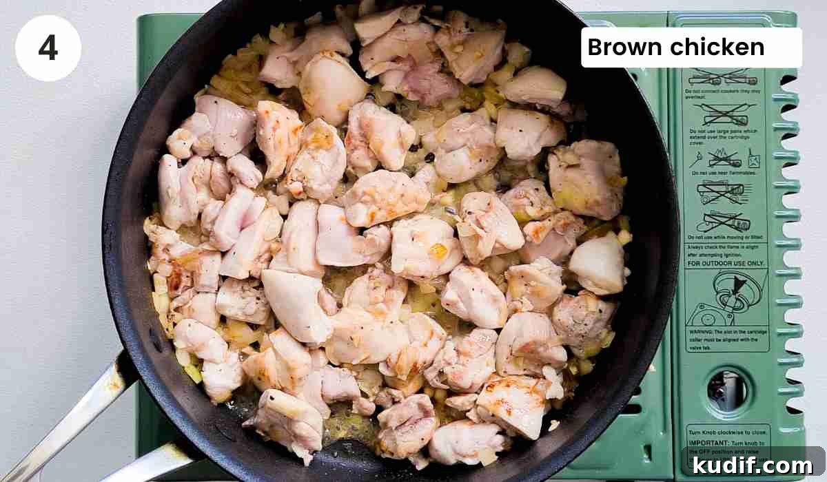 Creamy Chicken and Orzo Skillet Recipe 7 chicken cubes being browed in a frying pan with caption
