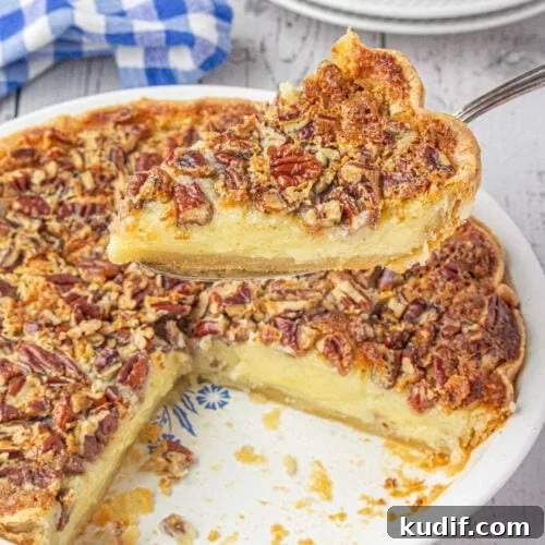 Closeup of a slice of creamy buttermilk pecan pie being served.