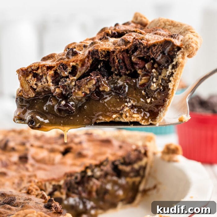 Decadent Chocolate Bourbon Pecan Pie Recipe 15 A slice of chocolate bourbon pecan pie being removed from the pie dish.