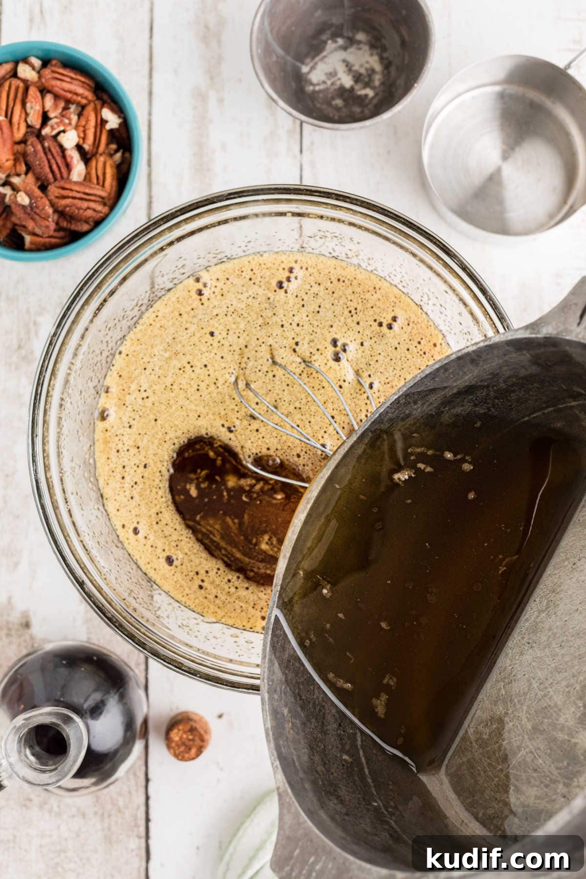 Decadent Chocolate Bourbon Pecan Pie Recipe 5 Brown butter mixture being poured into egg mixture.