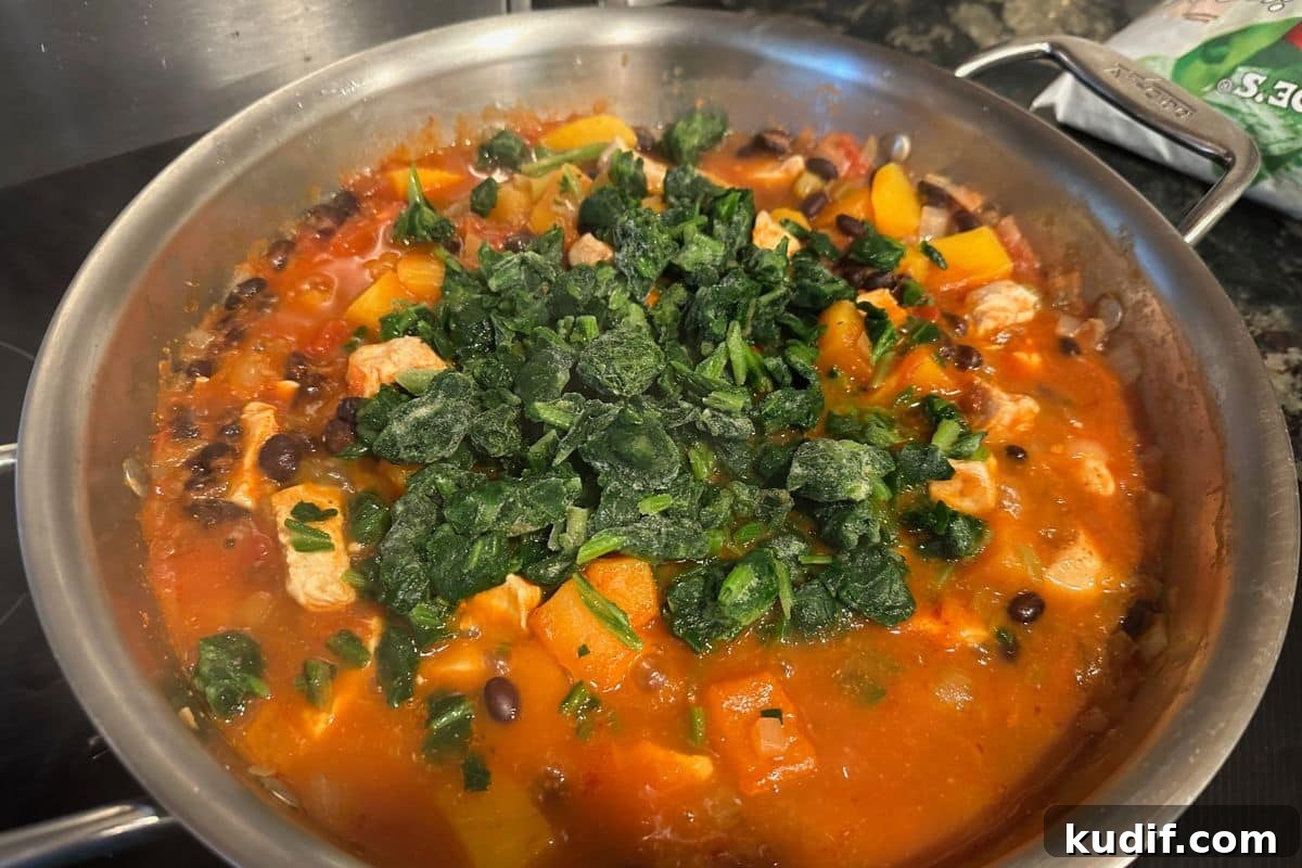 30-Minute Salsa Chicken Skillet Recipe for Quick Weeknight Dinners 7 Adding the frozen spinach to the pan.