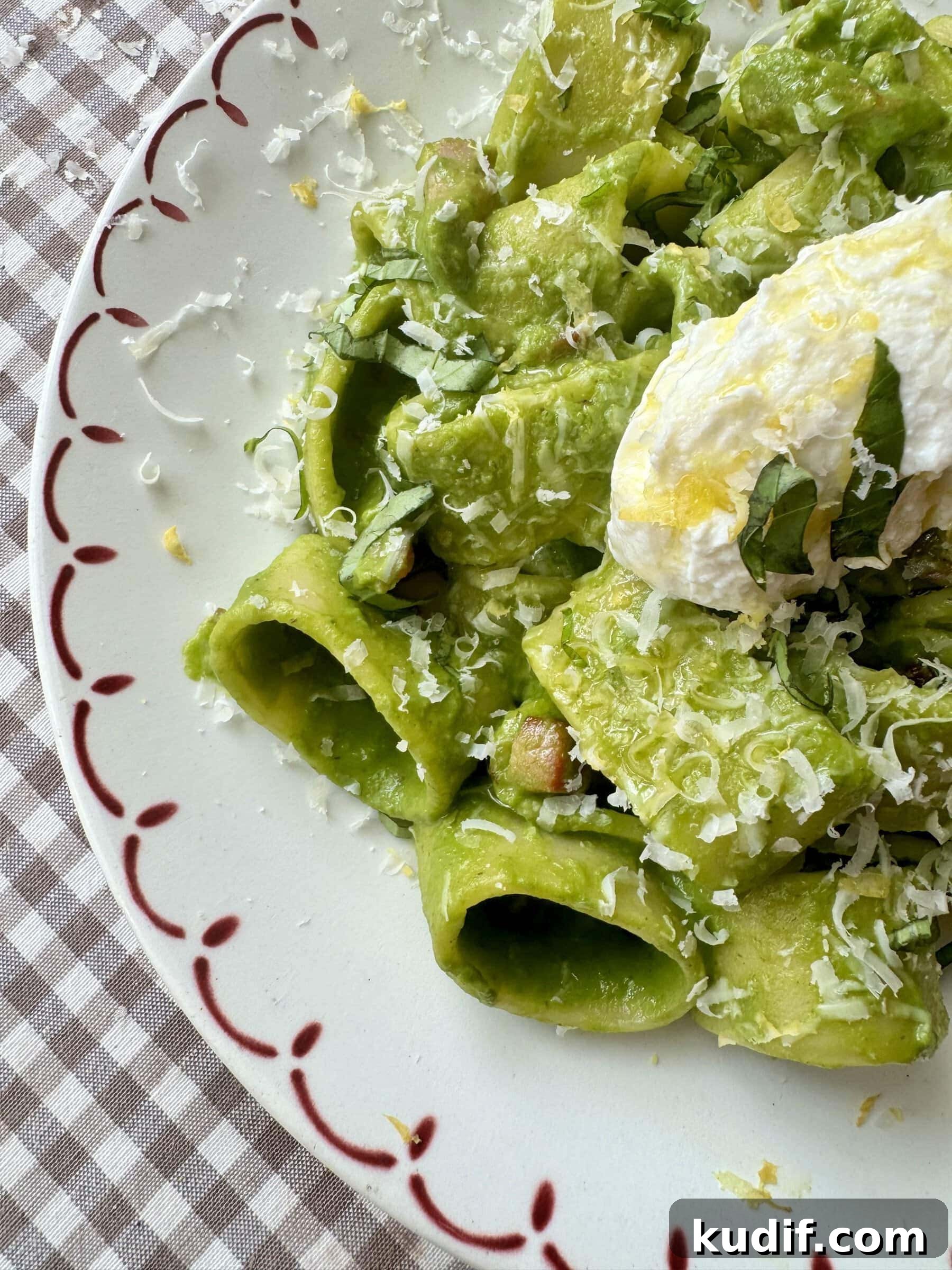 Creamy Spinach & Herb Pasta in Green Sauce 10 pasta in green sauce on a plate topped with cheese