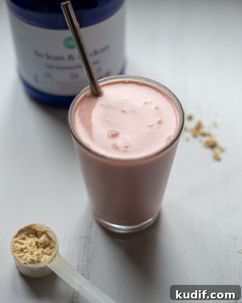 Vegan Strawberries and Cream Protein Breakfast Smoothie 4 45 degree angle looking into a glass full of pink strawberries and cream smoothie