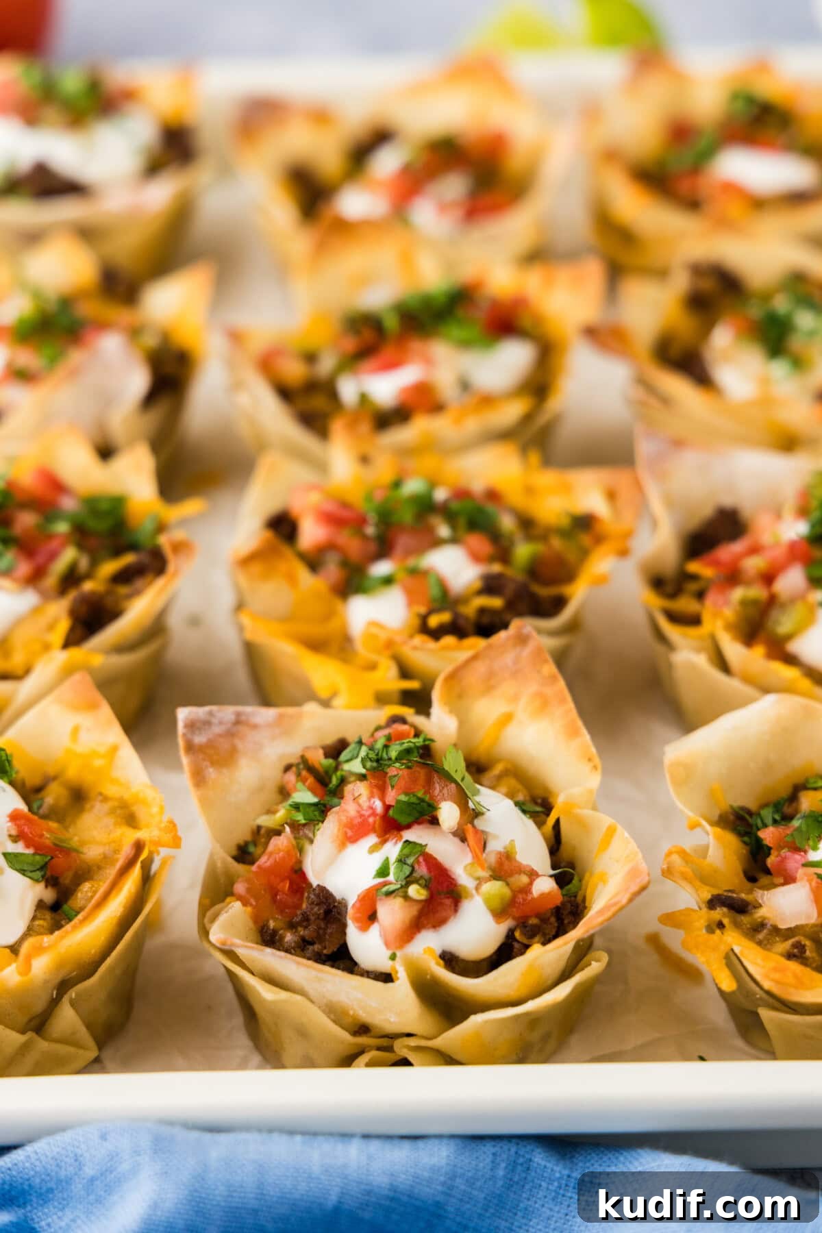Close up photo of Taco Cups topped with sour cream and Pico de Gallo